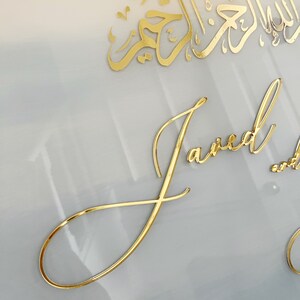 May include: A white background with gold calligraphy in Arabic script and the word "Janea" written in cursive gold lettering.