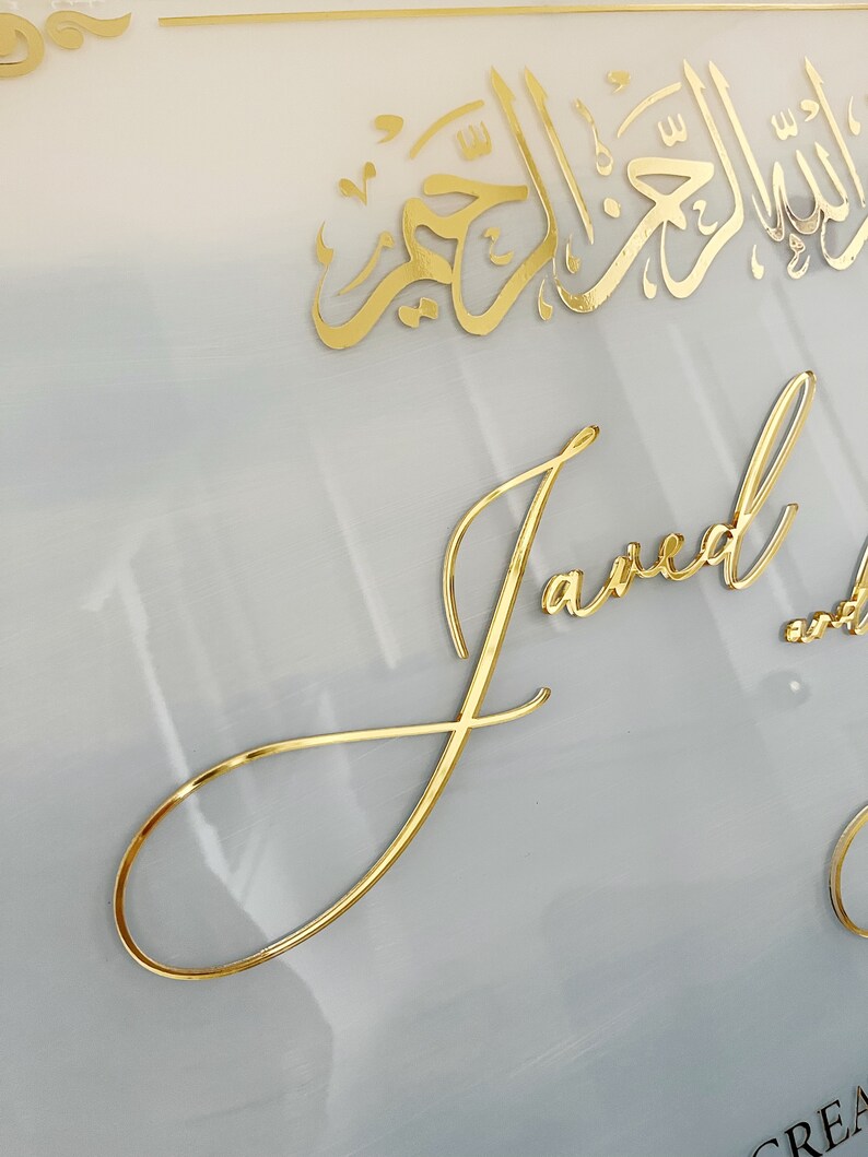 May include: A white background with gold calligraphy in Arabic script and the word "Janea" written in cursive gold lettering.