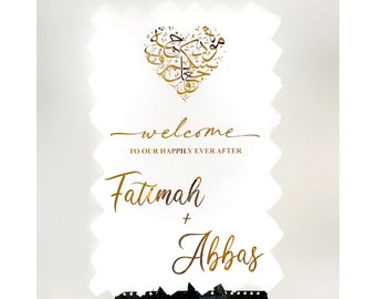 May include: White wedding welcome sign with gold calligraphy. The sign features a heart with Arabic calligraphy and the text "Welcome to our happily ever after Fatima + Abbas".