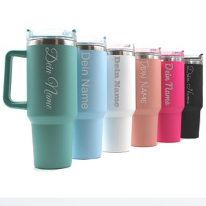 Può includere: Set di sei tazze da viaggio in acciaio inossidabile con manici. Le tazze sono di vari colori: verde acqua, azzurro, bianco, pesca, rosa e nero. Ogni tazza ha il testo "Dein Name" inciso sul lato.