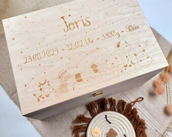 May include: A light wood keepsake box with a personalised inscription. The inscription reads "Joris 23.08.2024 - 12:02 Uhr - 3300g - 50cm". The box is decorated with a line of cartoon animals, including a zebra, elephant, lion, giraffe, and hippo.