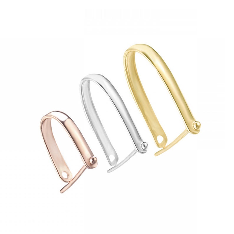 May include: Three different colored metal pendant bails. The bails are in gold, silver, and rose gold. The bails are all the same shape, but different sizes.