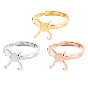 Könnte beinhalten: Drei Ringrohlinge in Gold, Silber und Roségold. Jeder Ring hat eine runde Zargenfassung und ein bogenförmiges Design.
