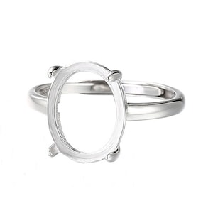 Könnte beinhalten: Ein silberner Ring mit einer ovalen Fassung für einen Edelstein. Die Fassung ist glatt und hat vier Krappen.