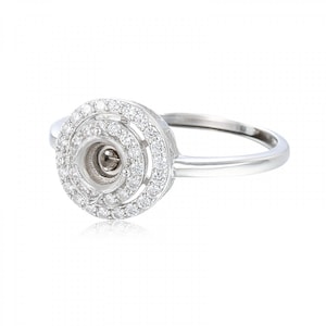 May include: A silver ring with a round center setting surrounded by two rows of small diamonds.