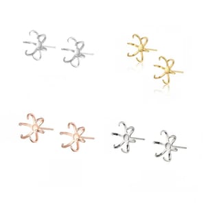 Puede incluir: Un juego de seis engastes para pendientes en tres acabados metálicos diferentes: plata, oro y oro rosa. Cada engaste presenta un diseño en forma de flor con seis garras para sujetar una perla u otra piedra preciosa.