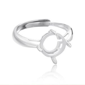 Puede incluir: Engaste de anillo de plata con bisel redondo para una piedra preciosa. El anillo es ajustable y tiene un diseño delicado.
