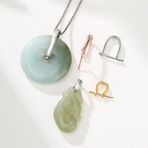 May include: Two jade pendants, one round and one shaped like a cloud, with silver bail and chain. Three different colored metal jump rings for jewelry making.