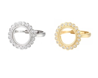 May include: Two adjustable rings with a round bezel set with clear stones. The ring on the left is silver and the ring on the right is gold.