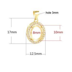 K&ouml;nnte beinhalten: Goldener Anh&auml;nger mit einer runden Zargenfassung mit einem Durchmesser von 8 mm, umgeben von einer Reihe von klaren Zirkonia-Steinen. Der Anh&auml;nger ist 17 mm hoch und 12,5 mm breit und hat ein 3 mm gro&szlig;es Loch f&uuml;r eine Kette.