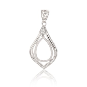 May include: Silver pendant with a teardrop-shaped opening, surrounded by a double-lined frame and accented with small clear stones.