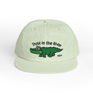 May include: A white ceramic mug with a black handle and the text "But First, Coffee" in a bold, black font. The mug is sitting on a wooden surface. The mug is approximately 4 inches tall.