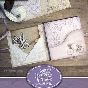 May include: A purple and white vintage lavender folio junk journal with a bicycle and floral design. The folio is open to reveal the inside pages and pockets.