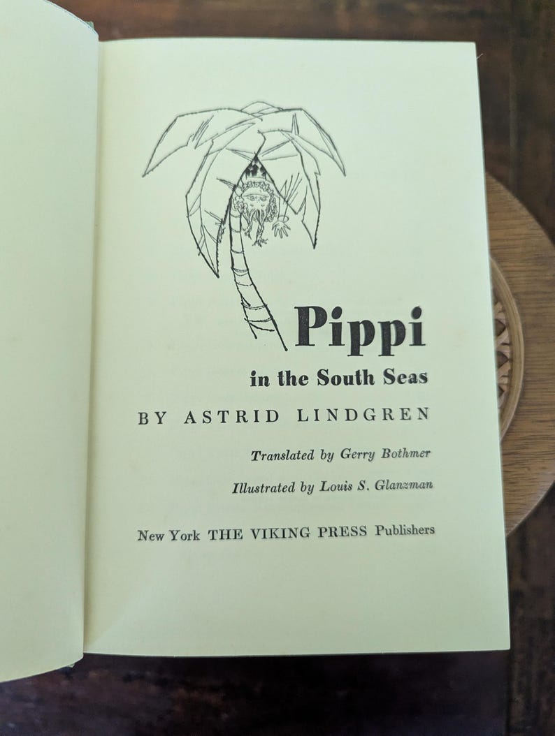 Pu&ograve; includere: Pagina di libro aperta con il titolo "Pippi in the South Seas" di Astrid Lindgren. L'immagine mostra un'illustrazione di una palma e il testo "Translated by Gerry Bothmer" e "Illustrated by Louis S. Glanzman".