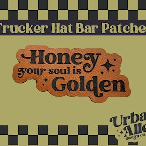 May include: A brown leatherette patch with the words "Honey your soul is Golden" in black script. The patch is designed for trucker hats and features a starburst design. The background is olive green.