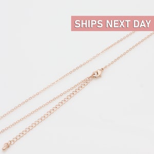 May include: A rose gold chain necklace with a lobster clasp closure. The chain is made of small, delicate links.