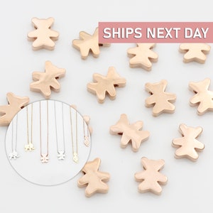 May include: Rose gold bear charm beads. The beads are small and have a slightly textured surface. The beads are arranged in a circle on a white background.  SHIPS NEXT DAY.