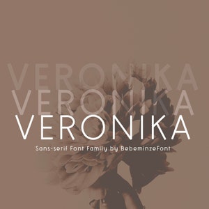 Puede incluir: Una familia de fuentes sans-serif llamada "Veronika" de BebeminzeFont. La fuente se muestra en blanco sobre un fondo marrón con una imagen borrosa de una flor.