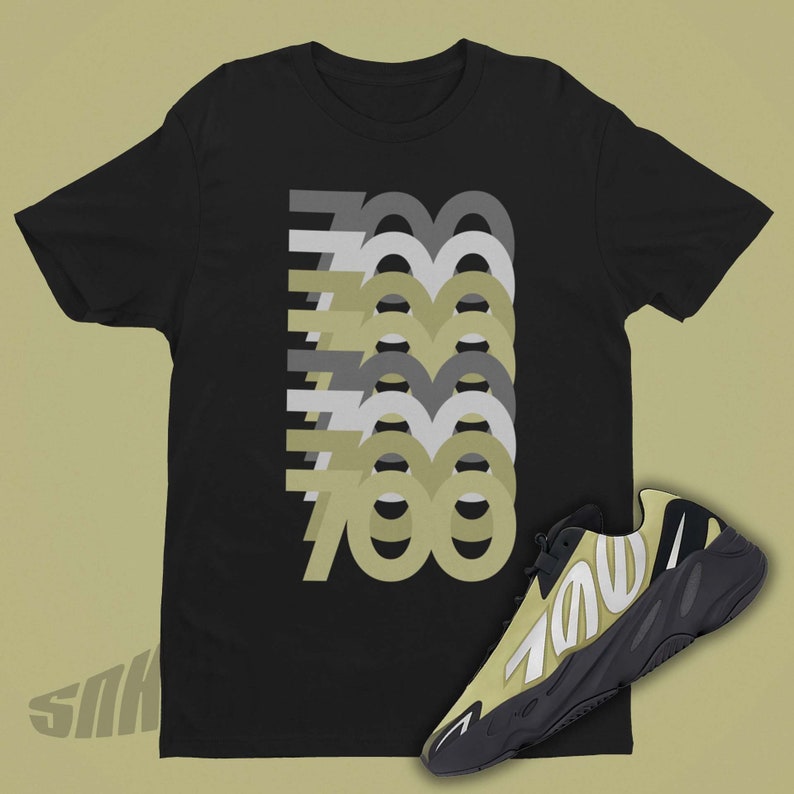 May include: A black t-shirt with a graphic of the number 700 repeated in different shades of gray and green. A pair of black and green sneakers with the number 700 on the side are shown below the t-shirt.