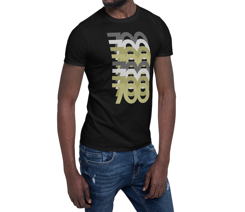 May include: A black t-shirt with a graphic design of the number 700 repeated in different shades of gray and gold.