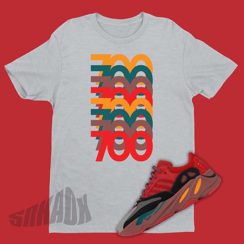 Puede incluir: Una camiseta gris con un gr&aacute;fico apilado del n&uacute;mero 700 en diferentes colores. La camiseta se combina con zapatillas rojas, naranjas y negras.