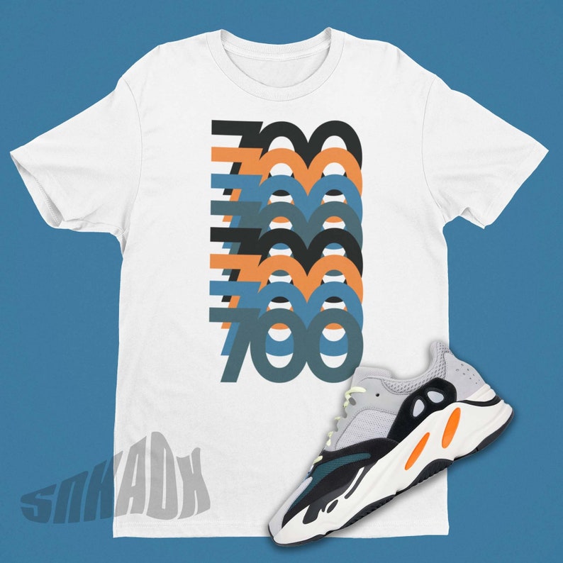May include: White t-shirt featuring a graphic of the number 700 repeated in various colours, paired with white, black, orange, and teal trainers.