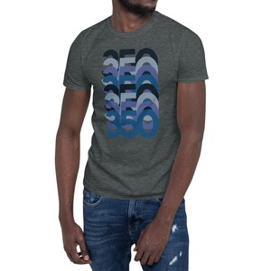 Peut inclure: Un t-shirt gris chin&eacute; fonc&eacute; avec un graphique r&eacute;tro du nombre 360 dans des tons bleus et violets.