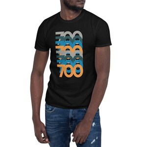 May include: Black t-shirt with a graphic of the number 700 repeated in a layered design with orange, blue, and gray colors.