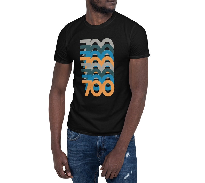 May include: Black t-shirt with a graphic of the number 700 repeated in a layered design with orange, blue, and gray colors.