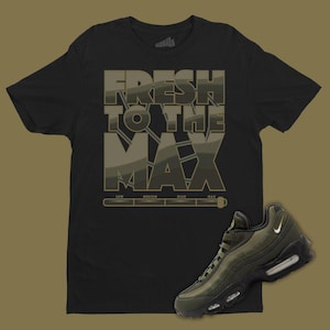 May include: Black t-shirt with a graphic print that says "Fresh to the Max" in a camouflage pattern. A pair of green and black sneakers are also pictured.