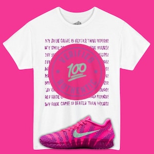 May include: White t-shirt with the text "MY SHOE GAME IS BETTER THAN YOURS!" repeated. A pink circle with "VERIFIED AUTHENTIC" and "100" is centered on the shirt. A pink and purple athletic shoe with a green swoosh is at the bottom.