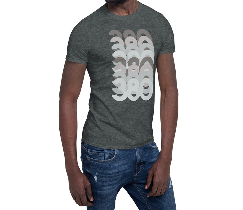 May include: A dark heather grey t-shirt with a graphic design of the number 360 repeated in a layered pattern. The numbers are in shades of grey.