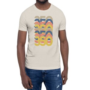 May include: A beige t-shirt with a graphic design of the number 350 repeated in a stacked, layered pattern. The numbers are in shades of yellow, orange, and blue.