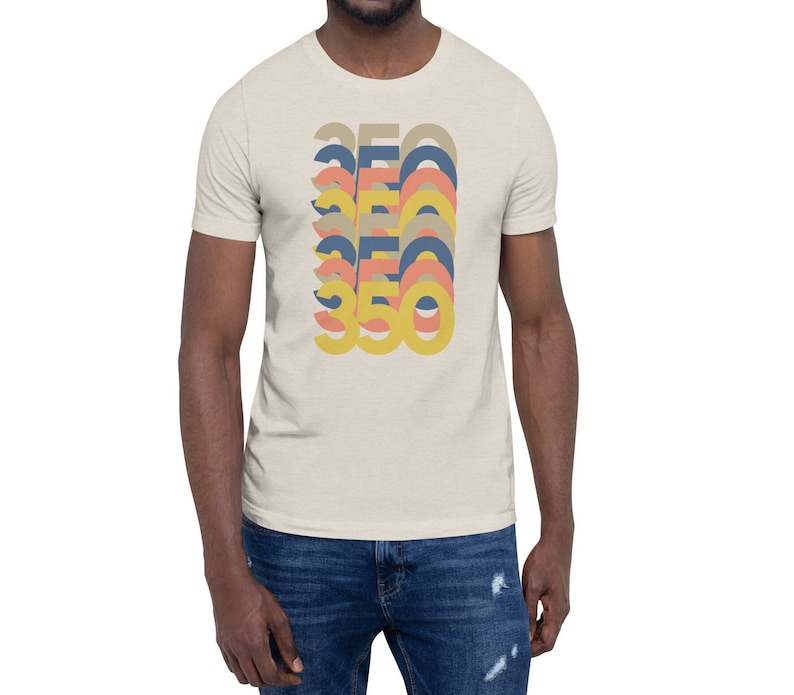 May include: A beige t-shirt with a graphic design of the number 350 repeated in a stacked, layered pattern. The numbers are in shades of yellow, orange, and blue.