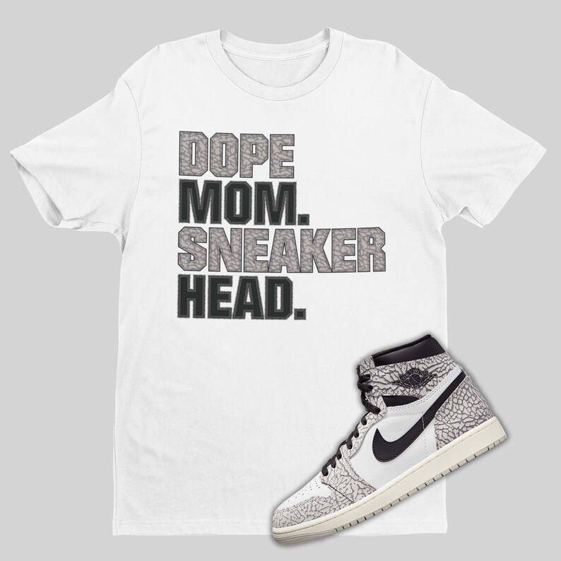 May include: White t-shirt with the text "Dope Mom. Sneaker Head." in black and gray. A white and gray sneaker with a black swoosh is on the bottom right of the image.