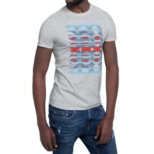 Puede incluir: Una camiseta gris claro con un dise&ntilde;o abstracto azul y rojo. El dise&ntilde;o es una serie de formas estilizadas superpuestas. La camiseta es de manga corta y est&aacute; hecha de un material suave.