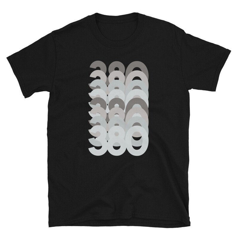 Puede incluir: Camiseta negra con un dise&ntilde;o gr&aacute;fico del n&uacute;mero 380 repetido en un efecto superpuesto y descolorido.