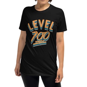 Pode incluir: Camiseta preta de manga curta com o texto "LEVEL 700" em letras laranja e azul.