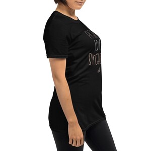 May include: Black short-sleeved t-shirt with the text "Pretty Love Sneakers" in a light brown color.