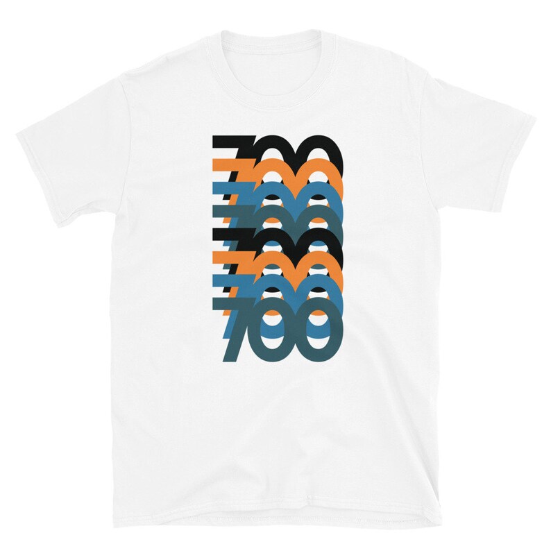 May include: White t-shirt featuring a graphic design of the number 700 repeated in a stacked pattern. The numbers are in black, orange, and blue.