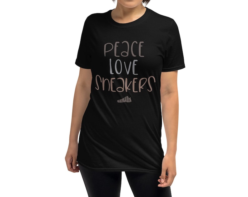 May include: Black short-sleeved t-shirt with the text "Peace Love Sneakers" in brown and white lettering.