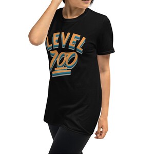 Pode incluir: Camiseta preta de manga curta com o texto "LEVEL 700" em letras laranja e azul.