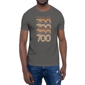 May include: A charcoal grey t-shirt with a retro-style graphic of the number 700 in brown, beige, and grey.