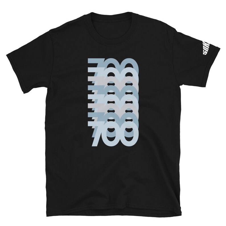 Puede incluir: Camiseta negra con un dise&ntilde;o gr&aacute;fico del n&uacute;mero 700 repetido en un patr&oacute;n azul degradado en capas.