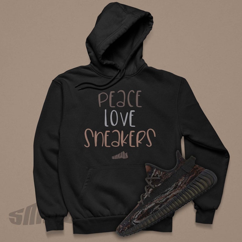 May include: Black hoodie with the text "peace love sneakers" in brown and white lettering. A pair of black and brown sneakers are in the bottom right corner of the image.