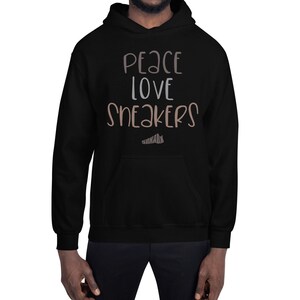 May include: Black hooded sweatshirt with the text "Peace Love Sneakers" in brown and white lettering.