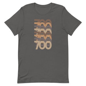 May include: A dark gray t-shirt with a retro-style graphic of the number 700 in different shades of brown, beige, and gray.