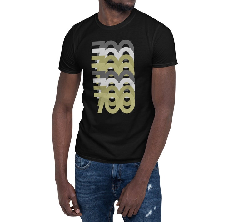 May include: A black t-shirt with a graphic design of the number 700 repeated in different shades of gray and gold.