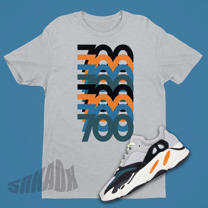Puede incluir: Una camiseta gris con un gr&aacute;fico del n&uacute;mero 700 repetido en diferentes colores y un par de zapatillas blancas, negras, verdes y naranjas.