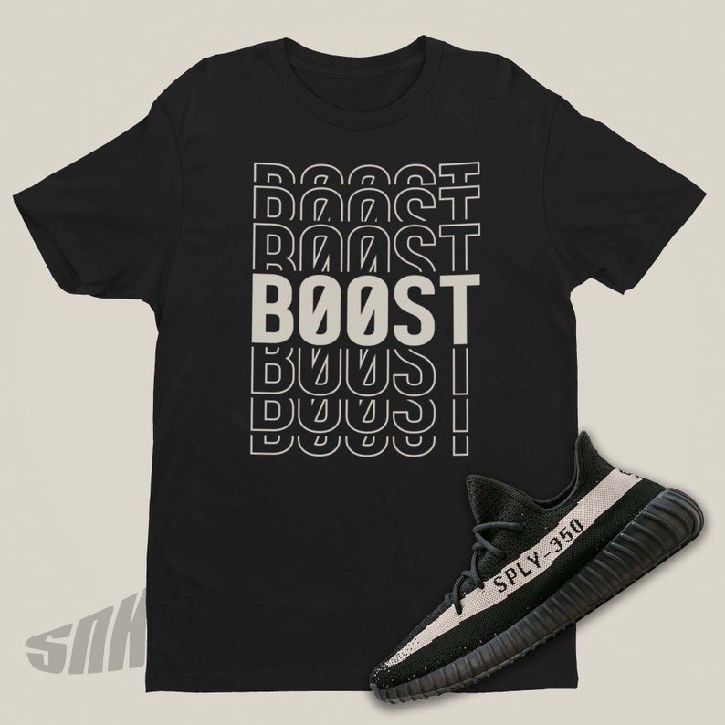 Puede incluir: Camiseta negra con la palabra "BOOST" repetida en un patr&oacute;n apilado en blanco. Una zapatilla negra y blanca con el texto "SPLY-350" en el lateral est&aacute; en la esquina inferior derecha de la imagen.